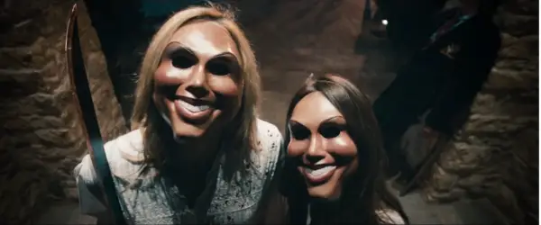 Two masked figures holding weapons in The Purge
