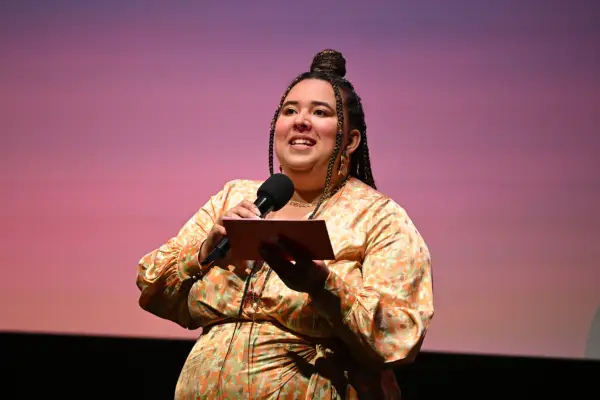 Grace Barber-Plentie on stage at the BFI Southbank holding cards and a microphone.