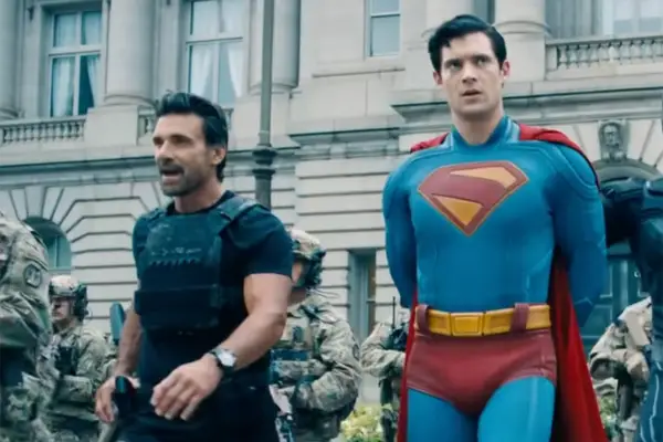 Frank Grillo and David Corenswet star as Rick Flag Sr and Superman; Rick is escorting a handcuffed Superman into a building with soldiers following behind them
