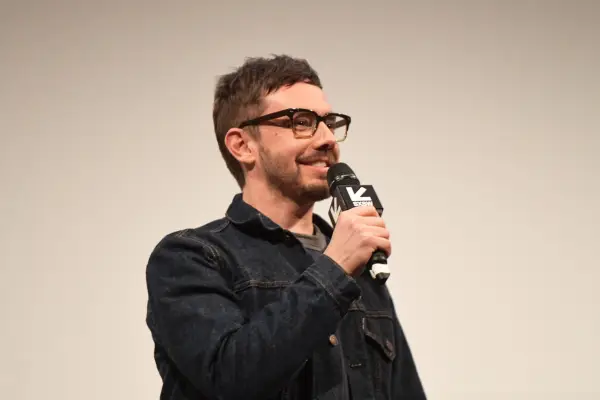 Jorma Taccone holding a microphone