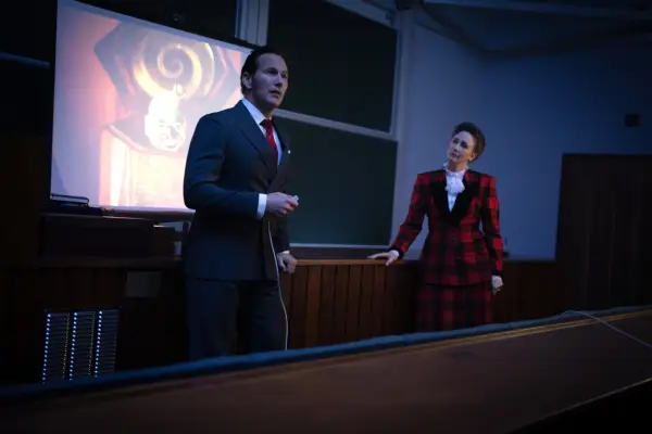 A girl sitting in a wheelchair as a nun speaks to her