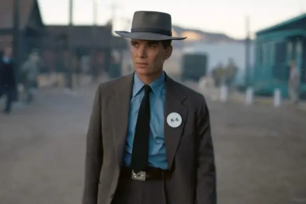 Cillian Murphy as J Robert Oppenheimer in Oppenheimer. He is wearing a grey suit and a hat.