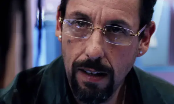 Anyone But You Glen Powell and Sydney Sweeney walking together with coffee cups smiling