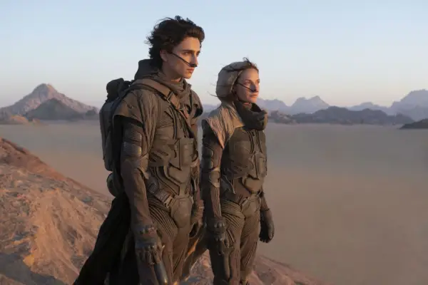 Timothée Chalamet as Paul and Rebecca Ferguson as Jessica in Dune overlooking the deserts of Arrakis.