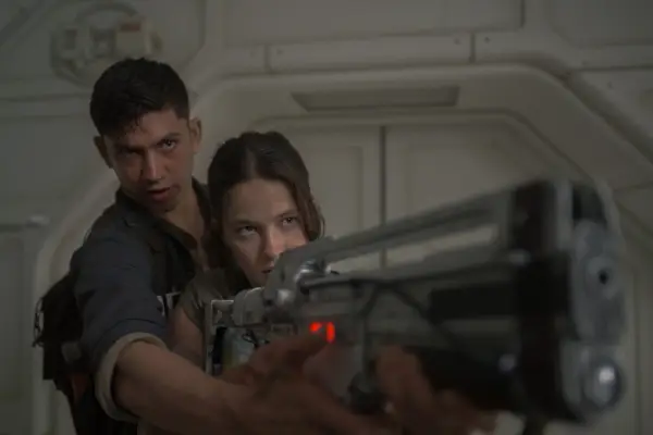 Cailee Spaeny and Archie Renaux in Alien: Romulus, pointing a gun together