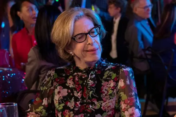 Jackie Hoffman as Irene in You Are So Not Invited to My Bat Mitzvah wearing a flowery top and glasses
