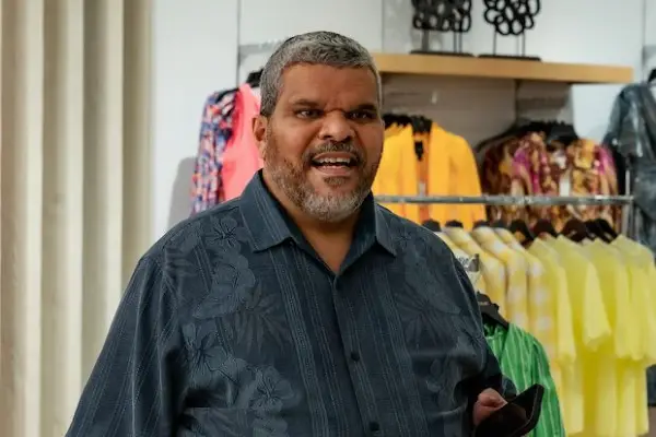 Luiz Guzman as Eli in You Are So Not Invited to My Bat Mitzvah wearing a dark shirt and holding his phone