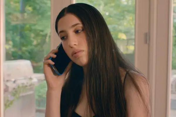 Sadie Sandler as Ronnie Friedman in You Are So Not Invited to My Bat Mitzvah with a phone to her ear