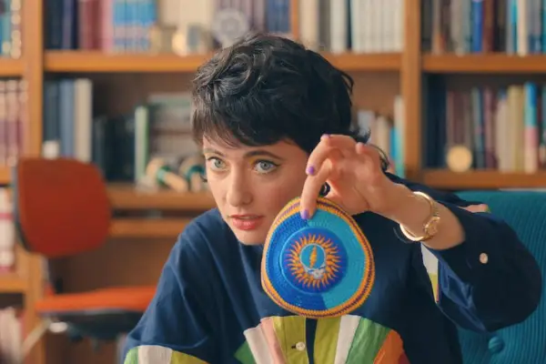 Sarah Sherman as Rabbi Rebecca in You Are So Not Invited to My Bat Mitzvah holding a knitted blue and orange item