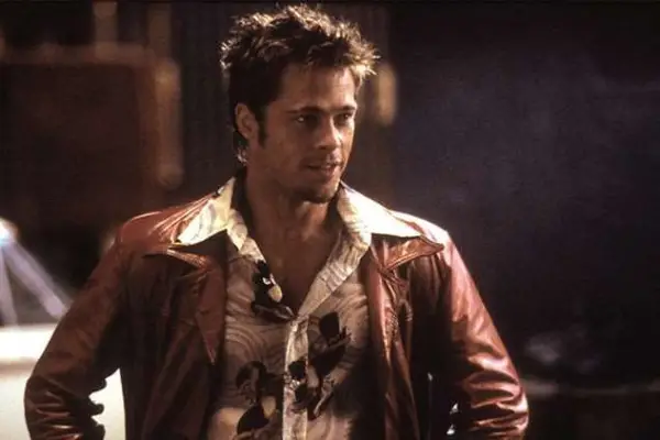 Brad Pitt wearing a leather jacket, smiling