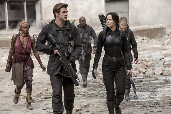 Liam Hemsworth and Jennifer Lawrence in The Hunger Games: Mockingbird - Part 1 walking in a group