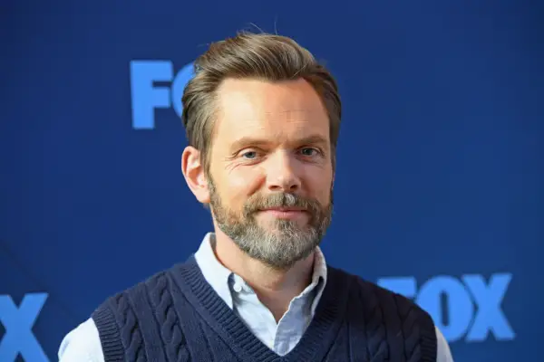 Joel McHale attends the FOX winter press junket in a blue sweater and shirt