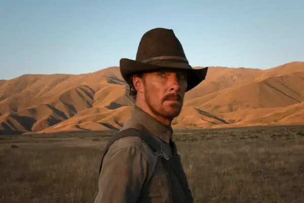 Phil Burbank (Benedict Cumberbatch) in The Power of the Dog wearing a hat, with mountains in the background