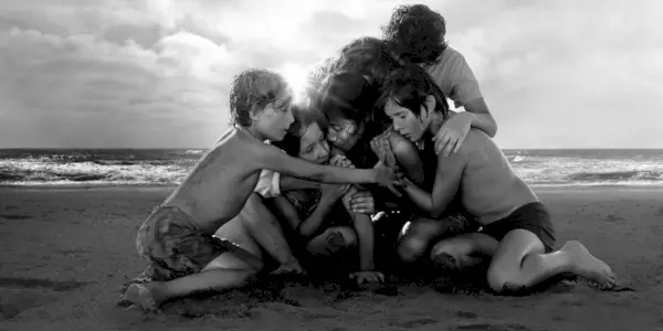 The cast of Roma, huddled on the beach