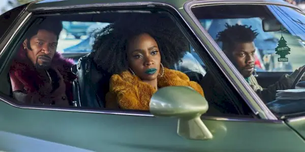 John Boyega driving a car with Teyonah Parris and Jamie Foxx