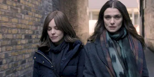 Rachel McAdams and Rachel Weisz walking together in an alley in Disobedience