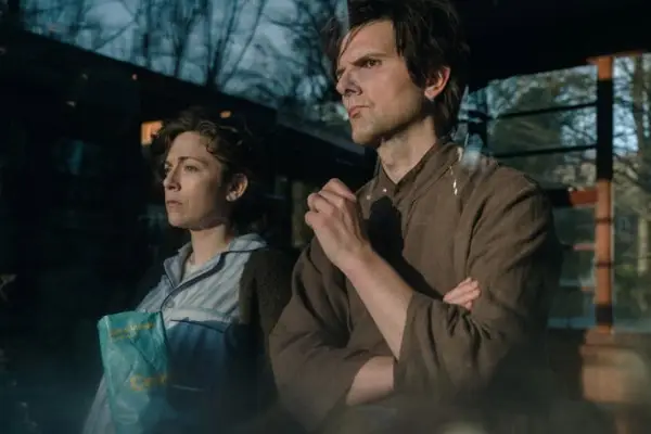 Adam Scott as Mark and Jen Tullock as his sister Devon in Severance standing together, looking out a window