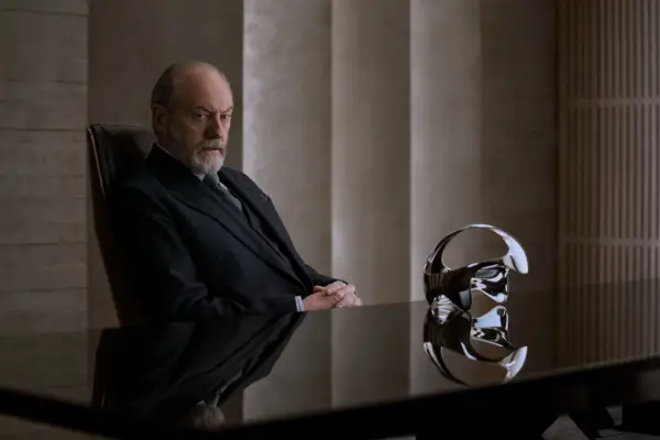 Liam Cunningham as Wade in 3 Body Problem sat by a strange metallic contraption