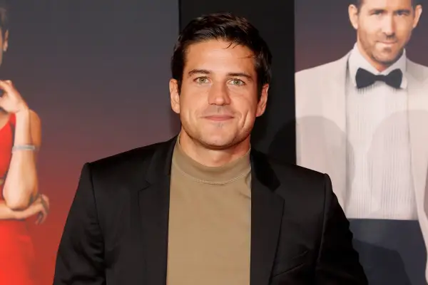 Marco Pigossi wearing a brown top and black blazer