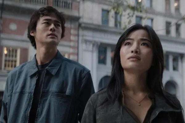 Ren Watabe as Kentaro and Anna Sawai as Cate Randa in Monarch: Legacy of Monsters standing on a street looking up.