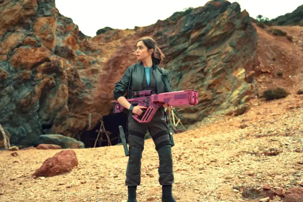 Cristin Milioti in Black Mirror season 7, holding a big pink gun and standing in the desert.