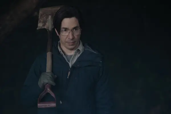 Justin Long as Mr. Bratt in Goosebumps holding a shovel in the night.