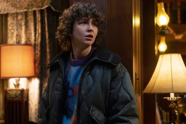 Miles McKenna as James in Goosebumps wearing a coat and looking out.