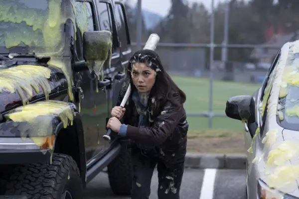 Ana Yi Puig as Isabella in Goosebumps covered in green slime and holding a baseball bat.