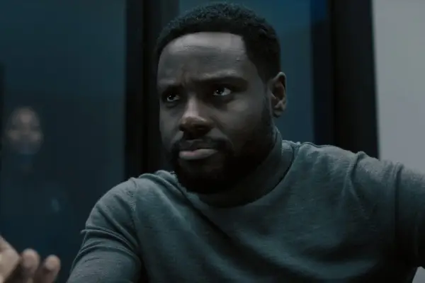 Dayo Okeniyi in Dark Matter wearing a grey top