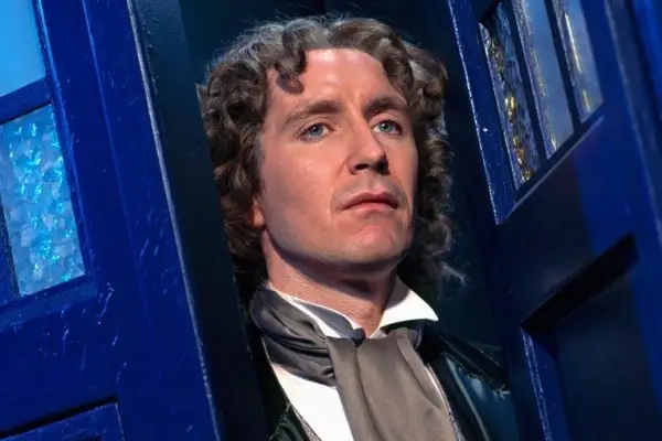 Paul McGann as the Eighth Doctor in Doctor Who standing in the doorway of the TARDIS