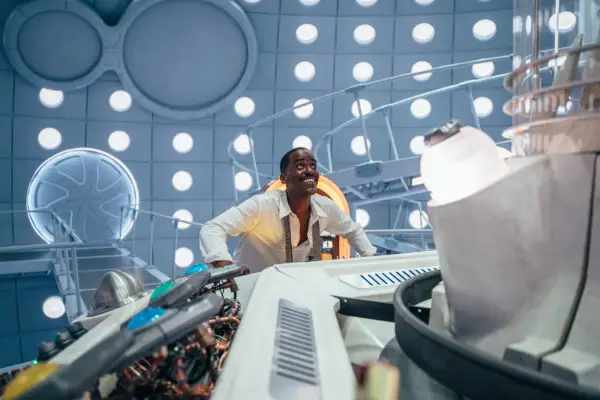 Ncuti Gatwa in Doctor Who in the TARDIS, resting on a console and looking skyward