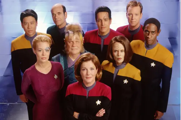 Cast of Star Trek: Voyager: Kate Mulgrew, Jeri Ryan, Ethan Phillips, Roxann Dawson And Tim Russ (Back Row, L To R) Garrett Wang, Robert Picardo, Robert Beltran And Robert Duncan Mcneill in Star Trek attire looking into camera