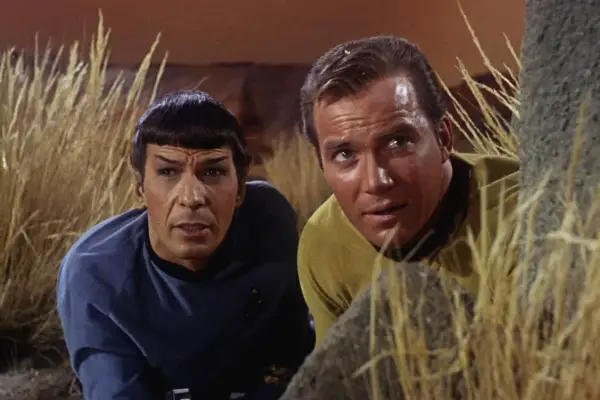 Leonard Nimoy as Mr. Spock and William Shatner as Captain James T. Kirk in Star Trek: The Original Series hiding in a grassy environment
