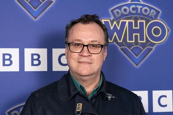 Russell T Davies in front of a backdrop with the 