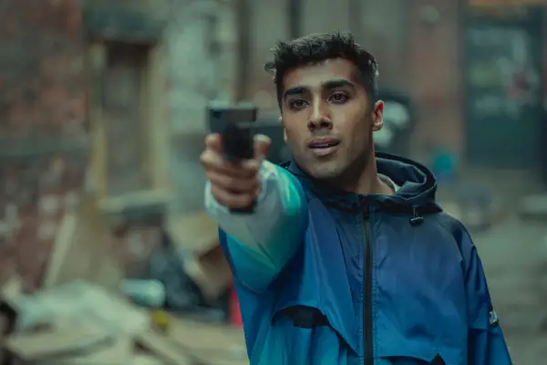 Chaneil Kular as Syed Tahir pointing a gun in Bodies.