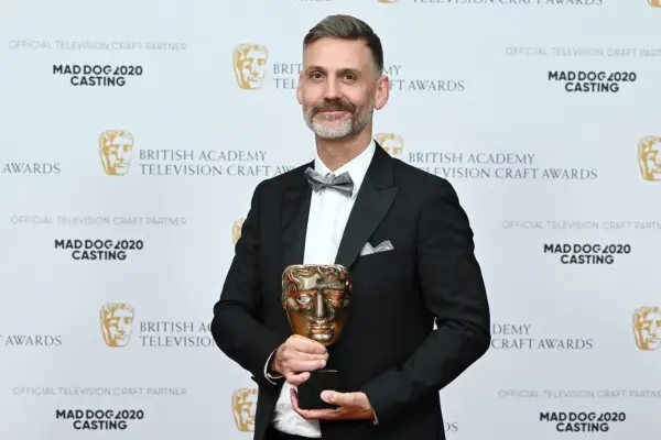 Peter Hoar holding a BAFTA award.