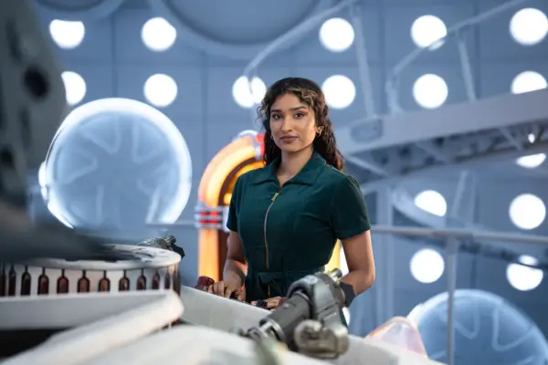 Varada Sethu as Belinda Chandra in Doctor Who in a green outfit in the TARDIS