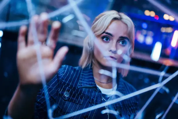 Millie Gibson as Ruby Sunday in Doctor Who. She is holding her hand up and there are cracks in front of her