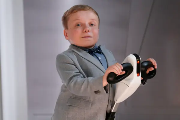 Lenny Rush as Morris in Doctor Who wearing a grey suit