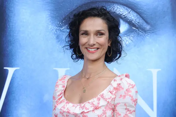 Indira Varma wearing a white and pink dress