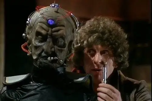 The Fourth Doctor stood next to an alien and holding up the sonic screwdriver.