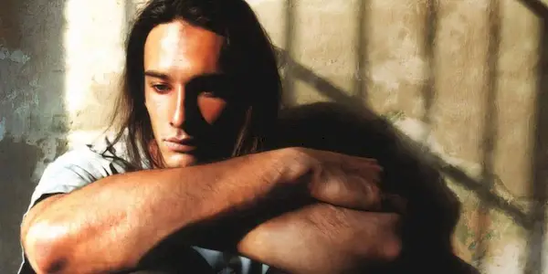 A man in prison looking pensive in Seven Heads