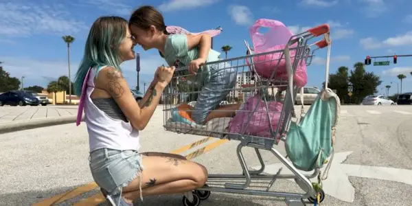 Bria Vinaite as Halley and Brooklynn Prince as Moonee bumping foreheads in 