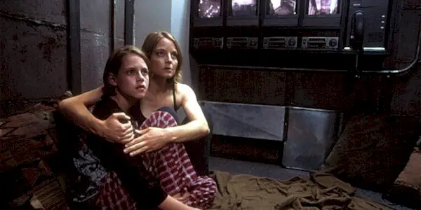 Meg Altman (Jodie Foster) holds her daughter (Kristen Stewart) as they look fearfully at something off screen in 