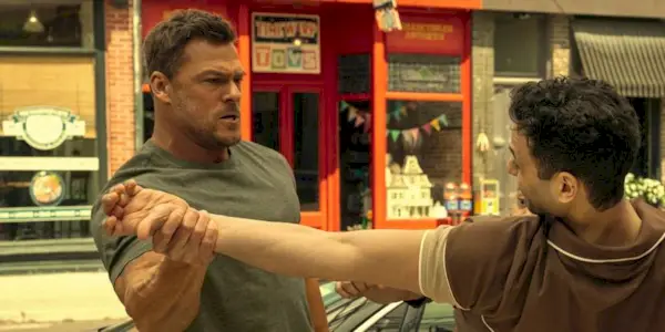 Alan Ritchson as Jack Reacher grabbing a man