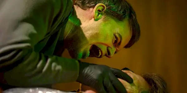 Dexter (Michael C. Hall) reaches out to someone while wearing gloves in 