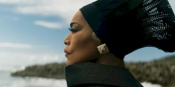 Angela Bassett as Queen Ramonda wearing black and looking somber in Black Panther - Wakanda Forever.