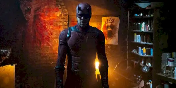 Charlie Cox in his Daredevil costume standing in an underground lair in 