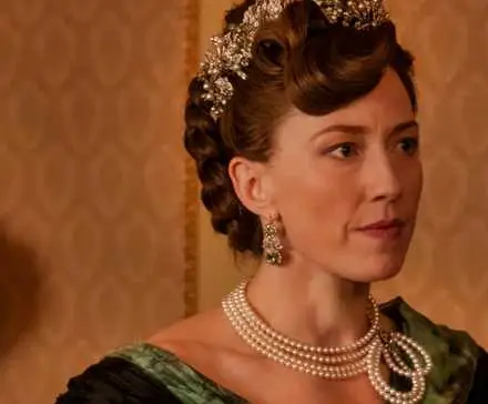 Carrie Coon in a fancy dress and jewelry looking off-camera in The Gilded Age Season 3 Episode 3.