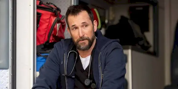 Robby (Noah Wyle) sitting alone in the back of an ambulance in The Pitt.